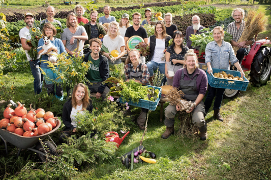 Een groep van ongeveer 20 boeren en hun producten in veilingkratten. Bron: aardpeer